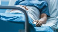 In the Hospital Sick Male Patient Sleeps on the Bed. Heart Rate Monitor Equipment is on His Finger.