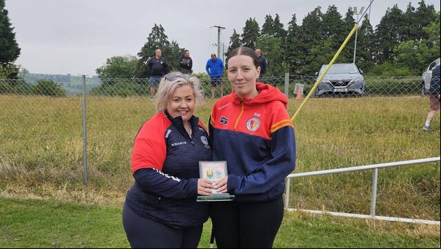 <p>Mairead Lynch, development officer Cork Camogie Board, presenting Rachel Murray with the adult Poc Fada trophy.</p>
